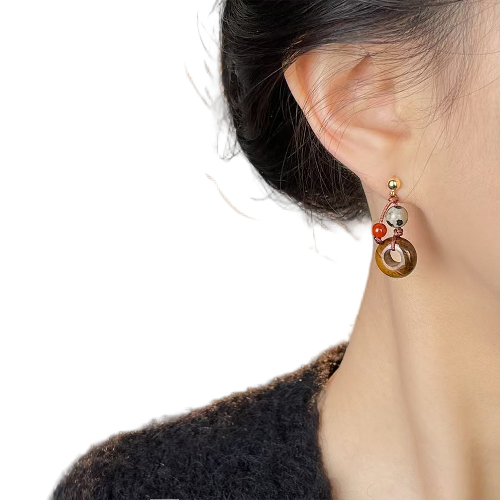 Close-up of an ear wearing a colorful earring