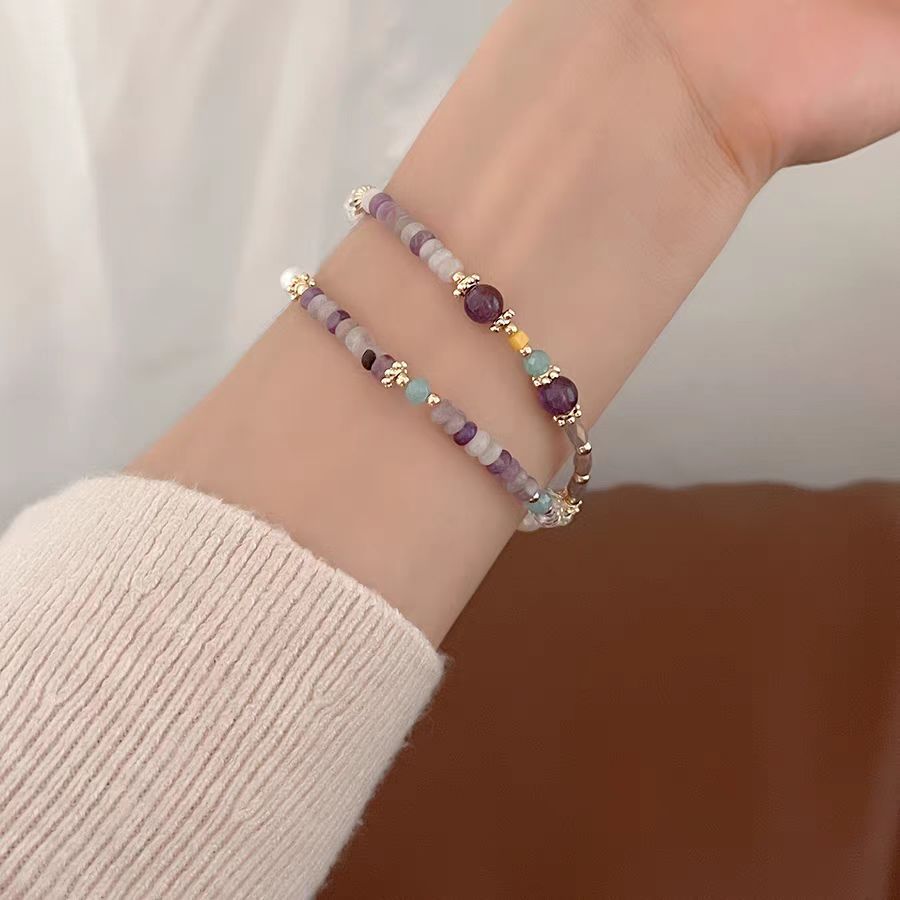 Beaded bracelet on a wrist with a neutral background