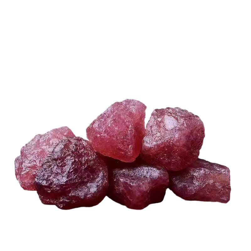 Pink gummy candies on a light surface with a bowl in the background