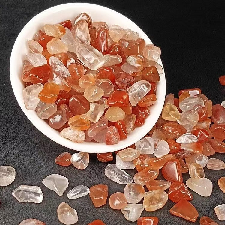 White bowl filled with multicolored gemstones on a dark surface