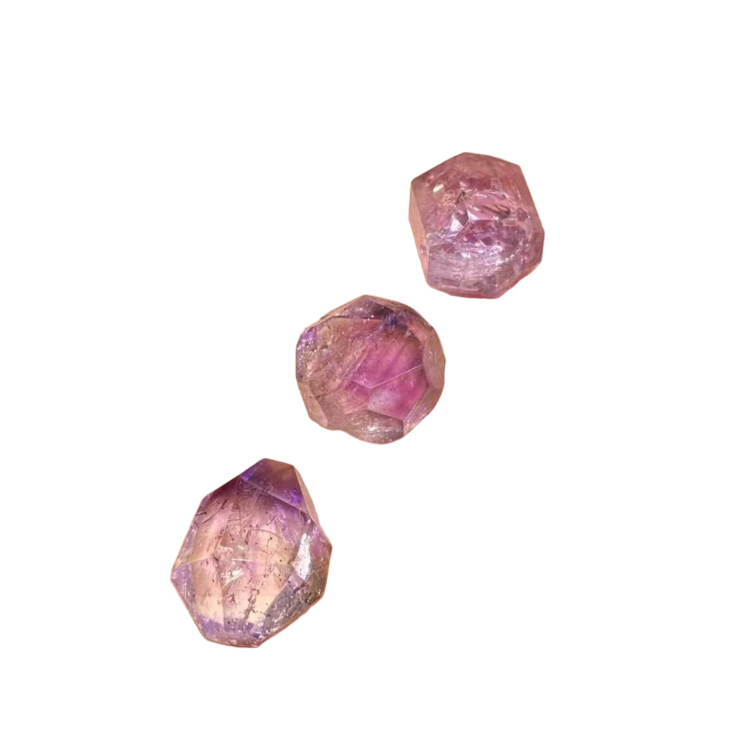 Three pink gemstones on a white background