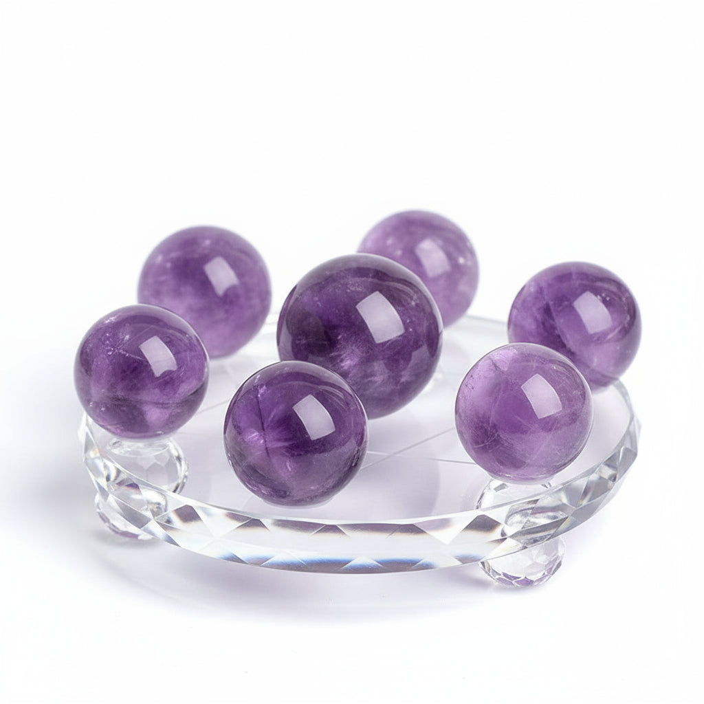 Purple crystal balls on a clear stand against a white background