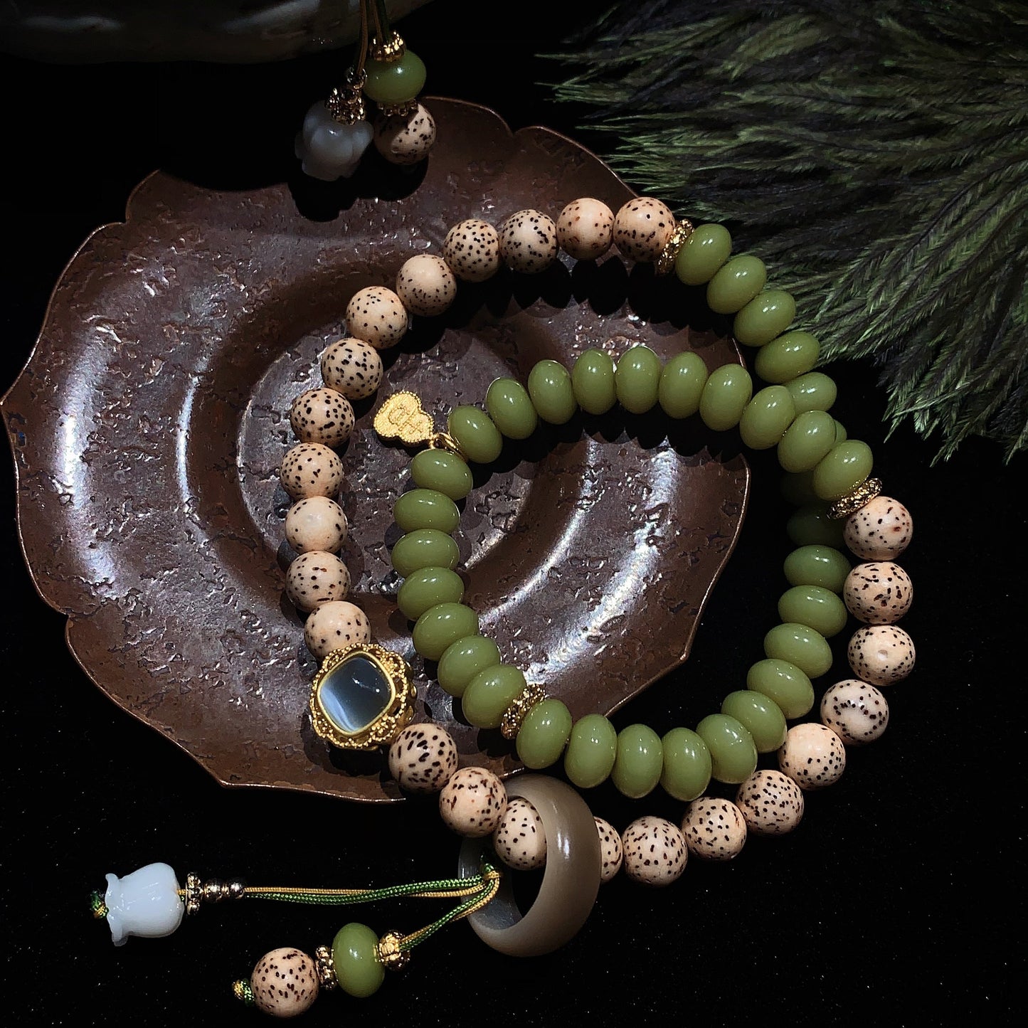 Beaded bracelets on a dark surface with a decorative dish
