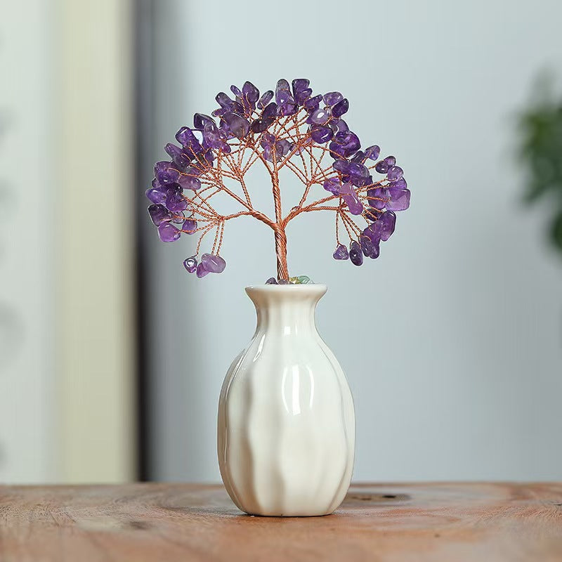 White vase with a decorative purple tree on a wooden surface