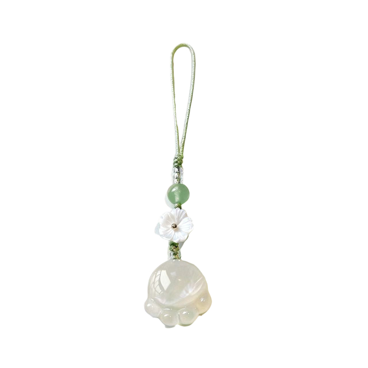 Decorative pendant with a white flower and green beads on a beige background