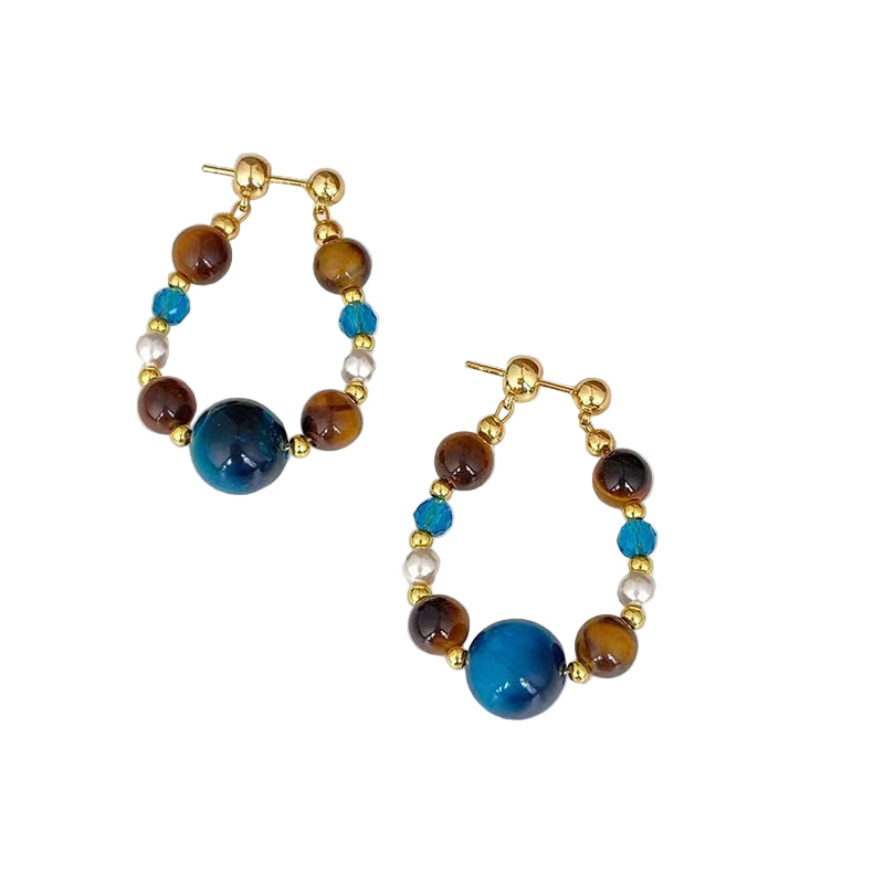 Pair of hoop earrings with blue and brown beads on a white surface