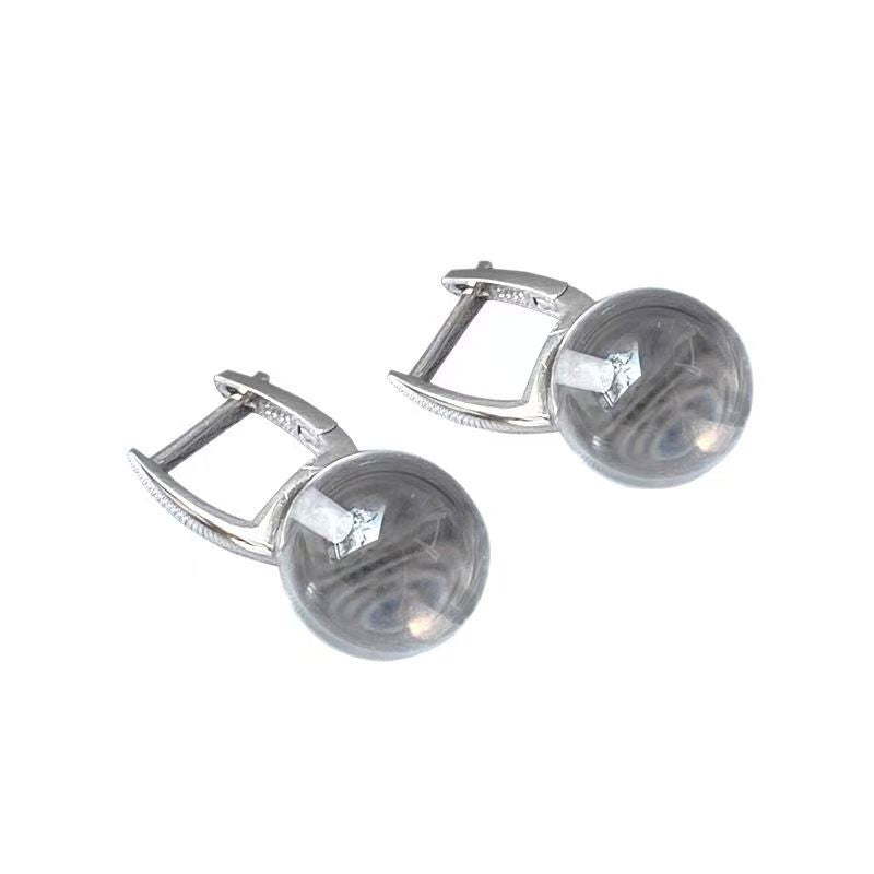 Pair of silver earrings with round gemstones on a white background