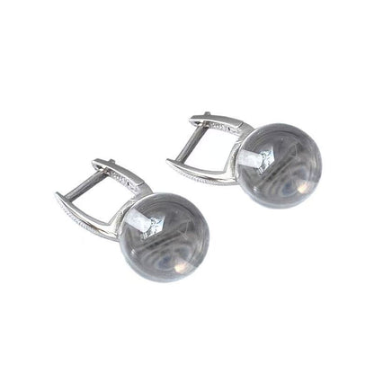 Pair of silver earrings with round gemstones on a white background