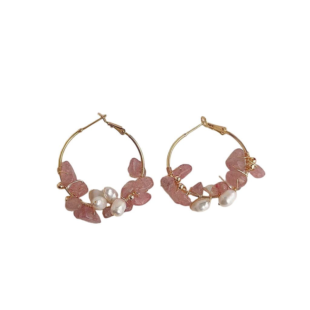 Gold hoop earrings with pink stones and pearls on a white background