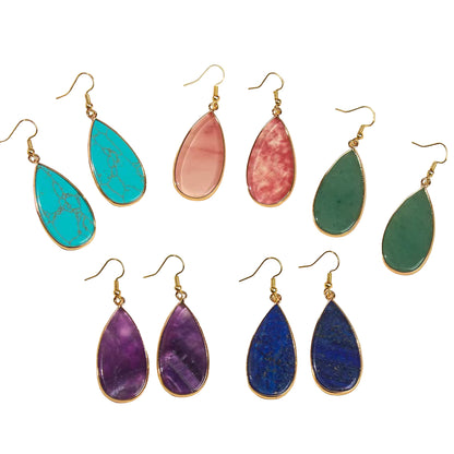Set of colorful teardrop earrings on a light background