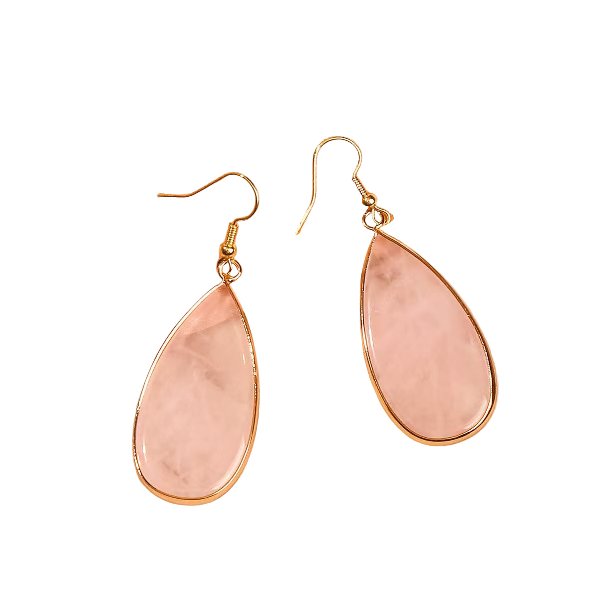 Teardrop-shaped pink earrings with gold accents on a soft pink fabric background