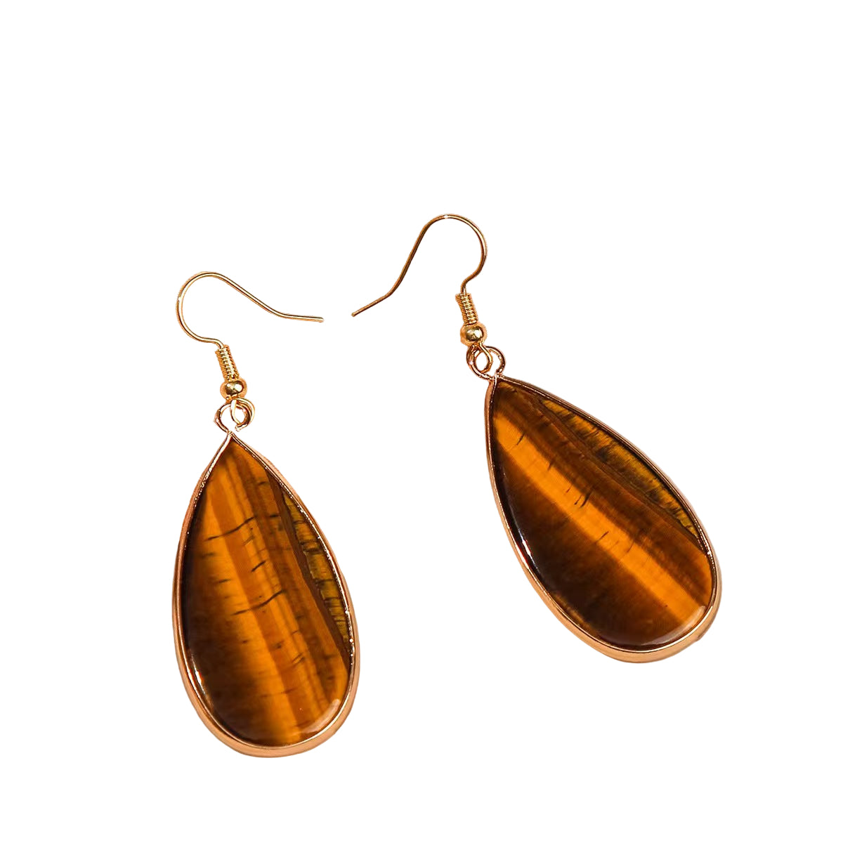 Teardrop-shaped tiger's eye earrings with gold hooks on a beige fabric background