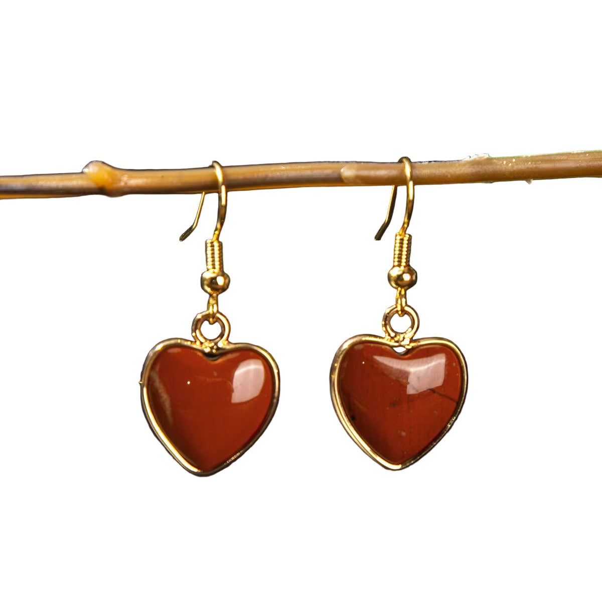 Heart-shaped earrings with gold frames on a dark background