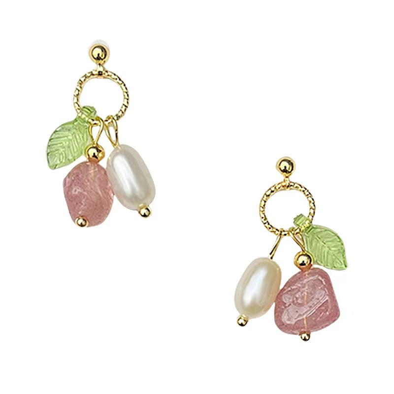 Pair of earrings with pink stones, pearls, and gold loops on a white background