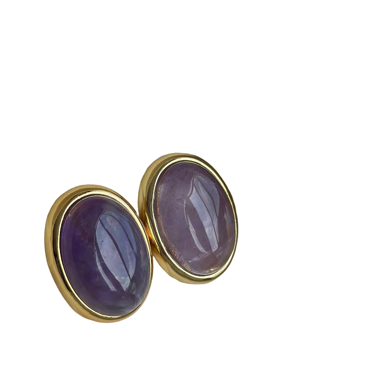 Gold earrings with purple stones in a jewelry box on a light blue background