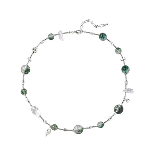 Necklace with green beads and silver chain on a white background