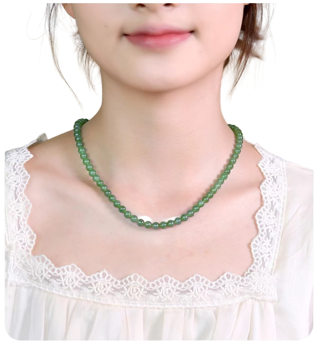 Person wearing a green beaded necklace with a white lace top