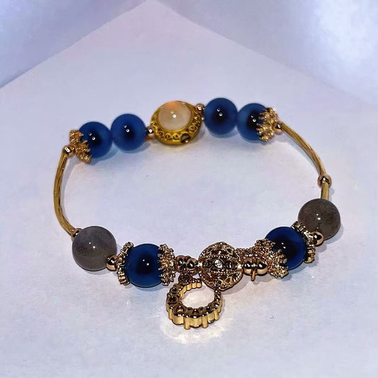 Bracelet with blue beads and gold accents on a white background
