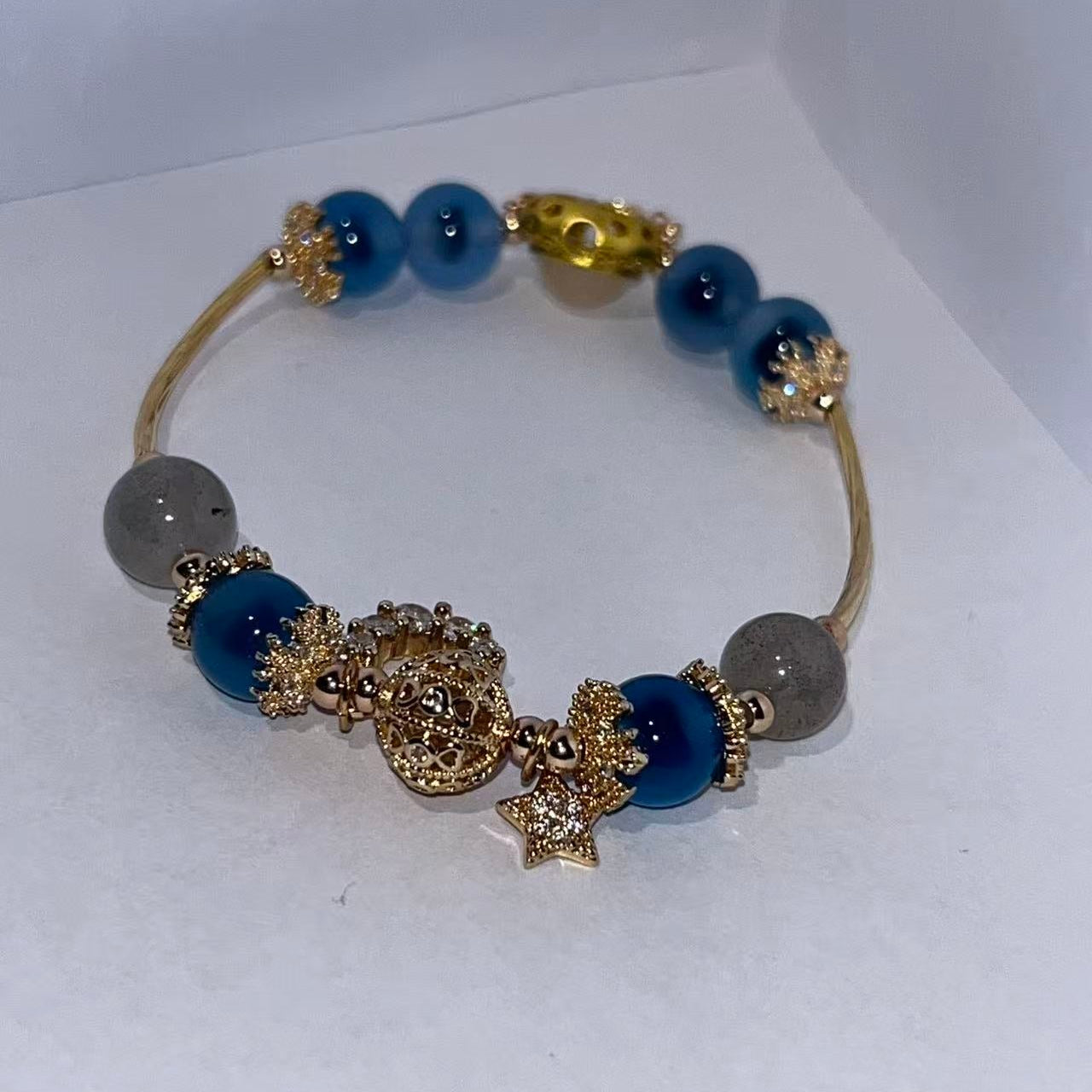 Bracelet with blue and gold beads on a white background