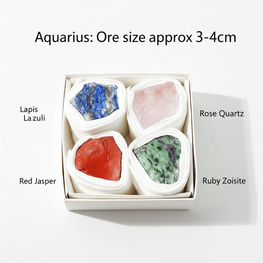 Box of crystals labeled Aquarius with four stones: Lapis Lazuli, Rose Quartz, Red Jasper, and Ruby Zoisite on a beige background.