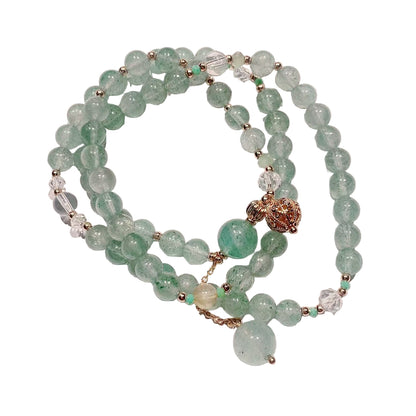 Green beaded bracelet with gold accents on a white background