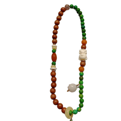 Beaded necklace with brown, green, and white beads on a white background