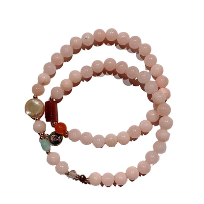 Beaded bracelet with pink beads and colorful accents on a white background