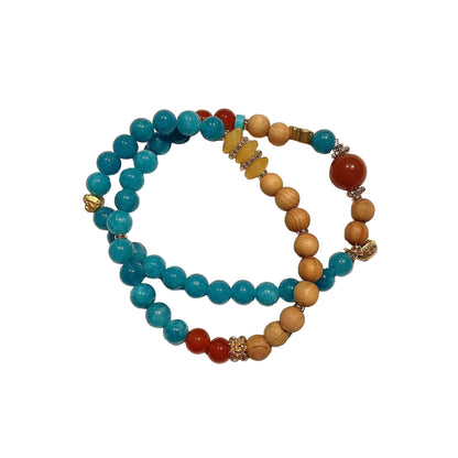 Two beaded bracelets, one with blue beads and the other with a mix of brown, red, and gold beads, on a light white background.