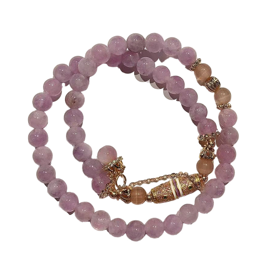 Stack of purple beaded bracelets with gold accents on a white background