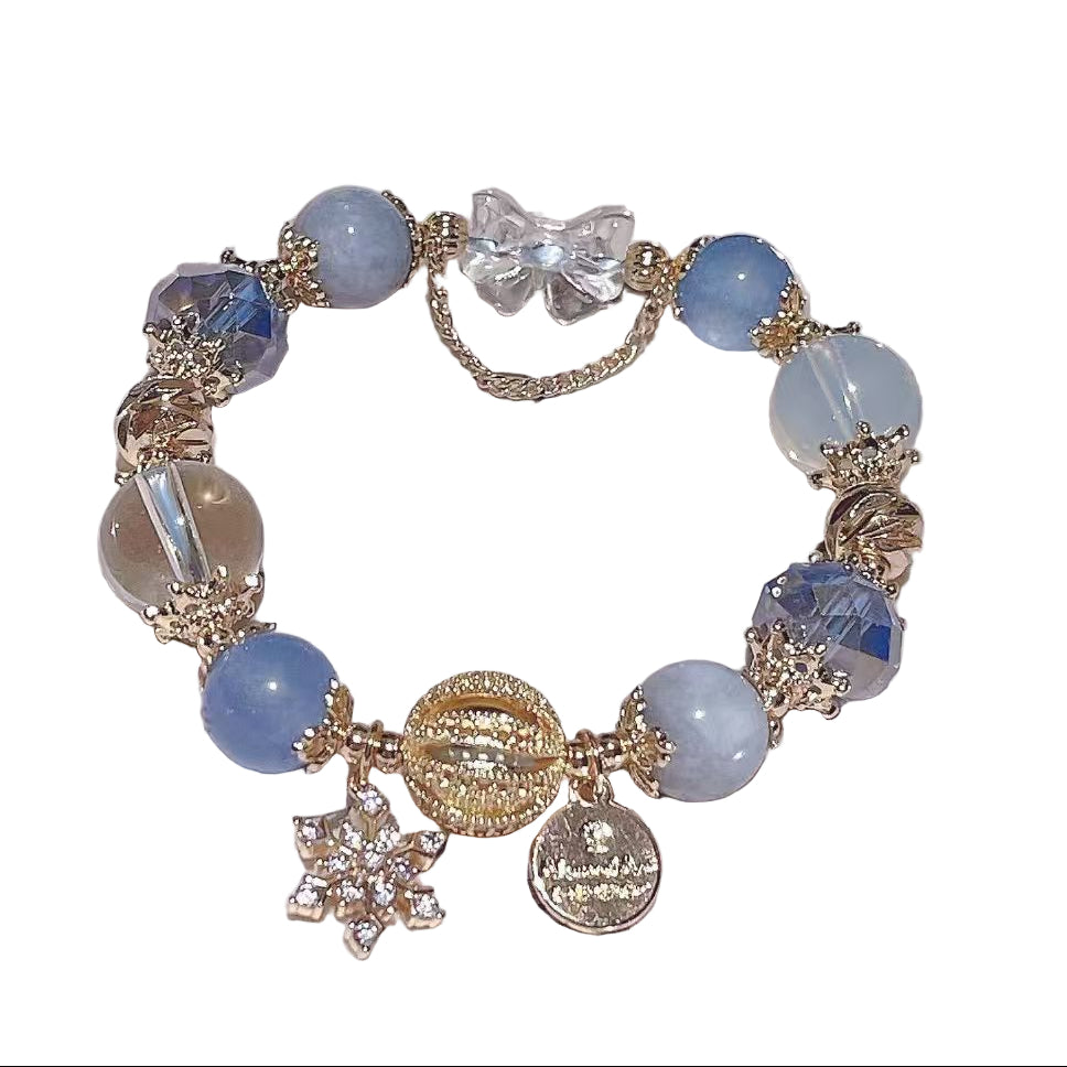 Delicate bracelet with blue beads and gold accents on a white surface