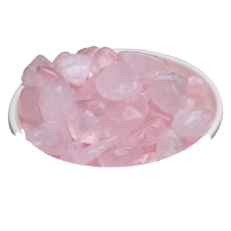 Pink crystal stones in a white bowl on a white background