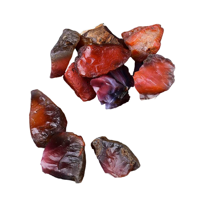 Raw gemstones in a black dish on a dark surface with a light background