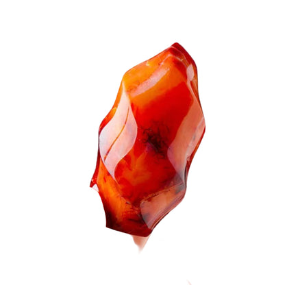 Hand holding a red and orange stone against a white background