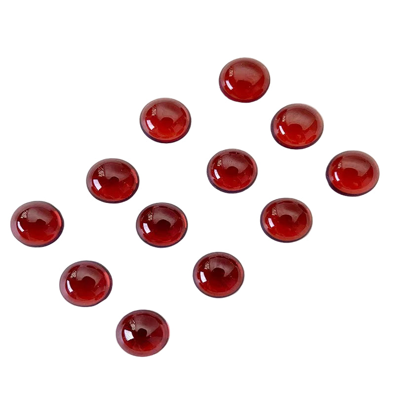 Red gemstones arranged in a circular pattern on a white background 