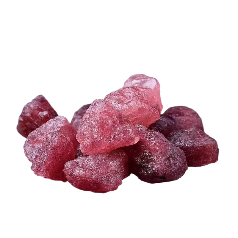 Pink rock candy pieces on a dark surface with a metallic object in the background