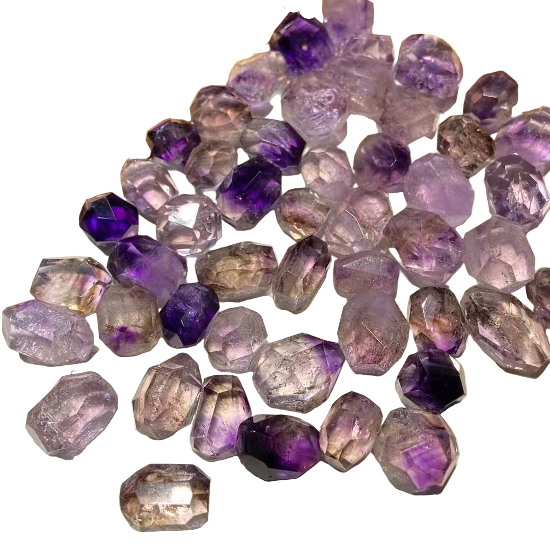 Collection of purple and clear gemstones on a white  surface
