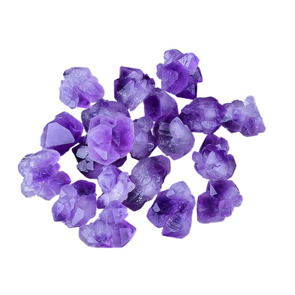Purple crystal rocks on a white surface 