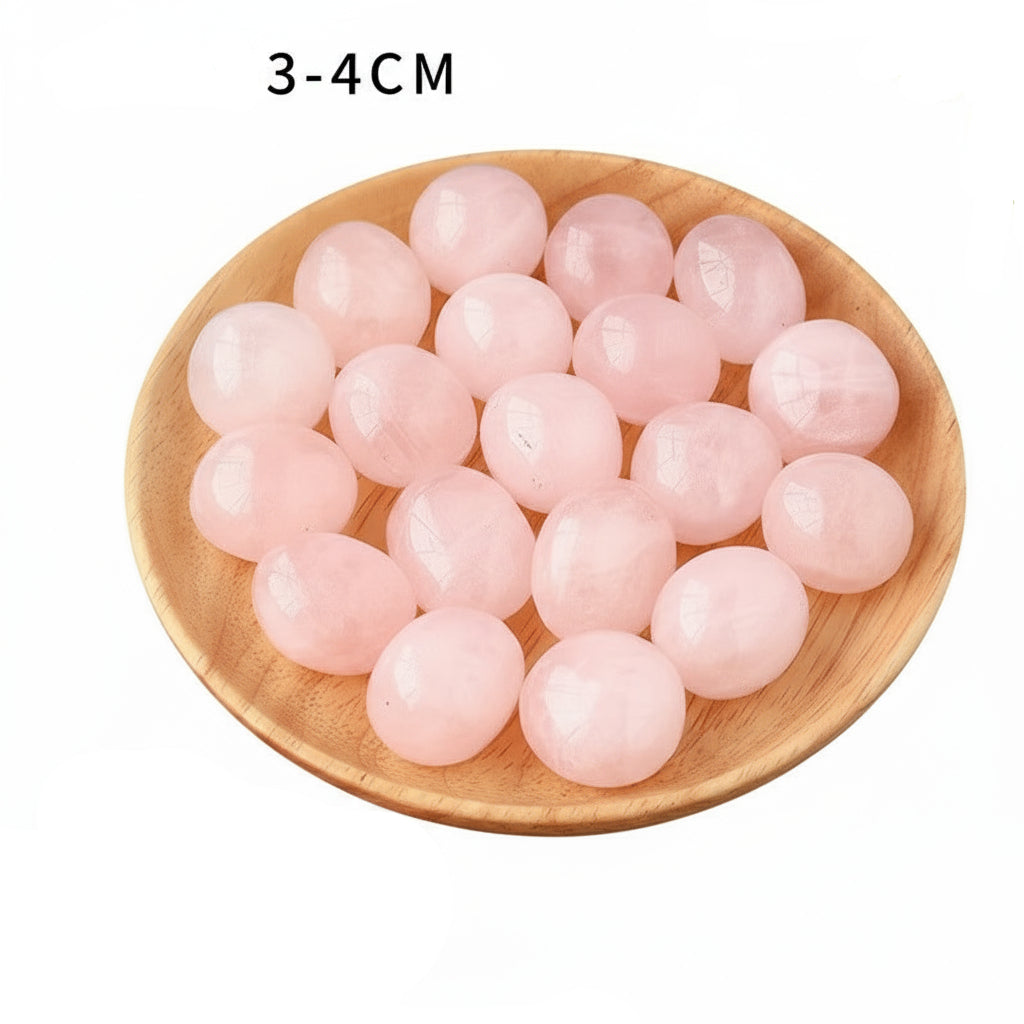 Pink crystal eggs on a wooden plate in a white background