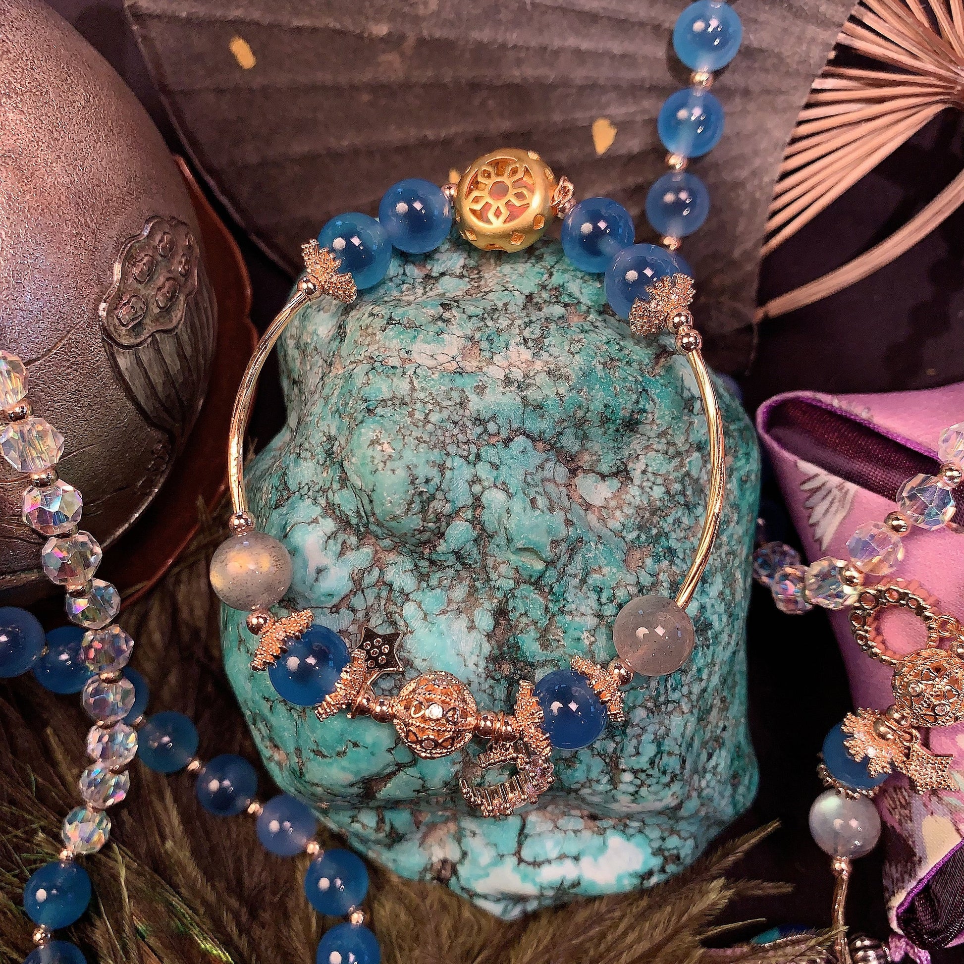 Jewelry set with blue beads and gold accents on a textured surface