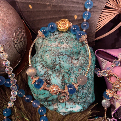 Jewelry set with blue beads and gold accents on a textured surface