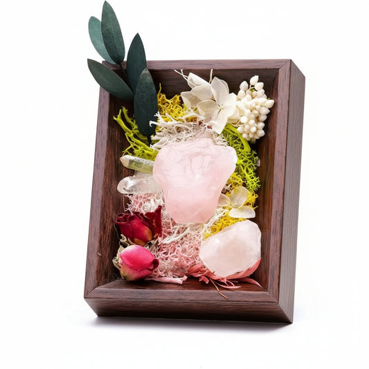 Decorative arrangement of flowers and leaves in a wooden frame on a whitr background