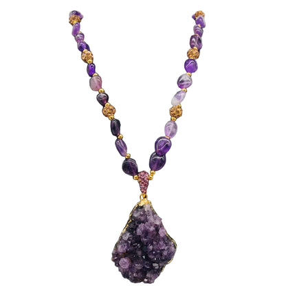Necklace with purple beads and a large purple stone pendant on a black mannequin against a white background
