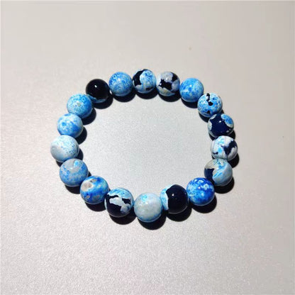 Beaded bracelet with blue and black marbled pattern on a light gray background